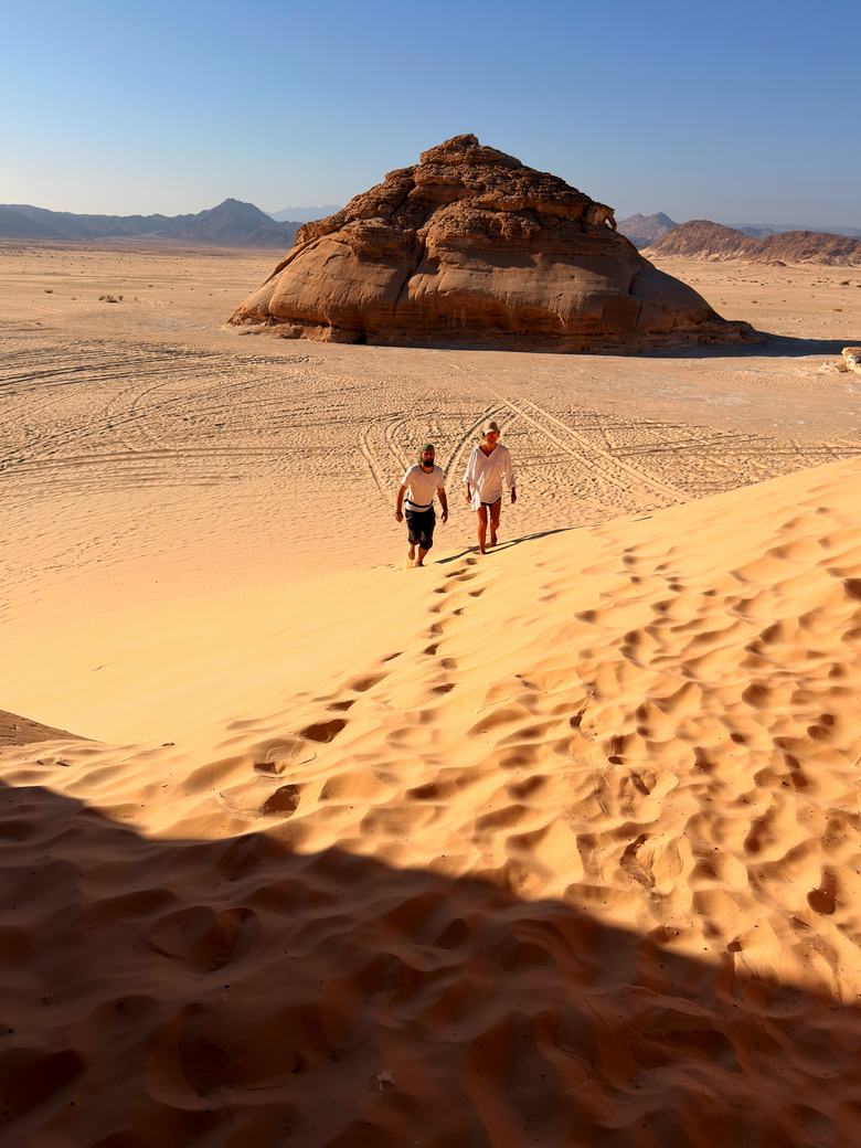 Egipto kelionė – du keliautojai leidžiasi kopa link uolos Sinajaus dykumoje