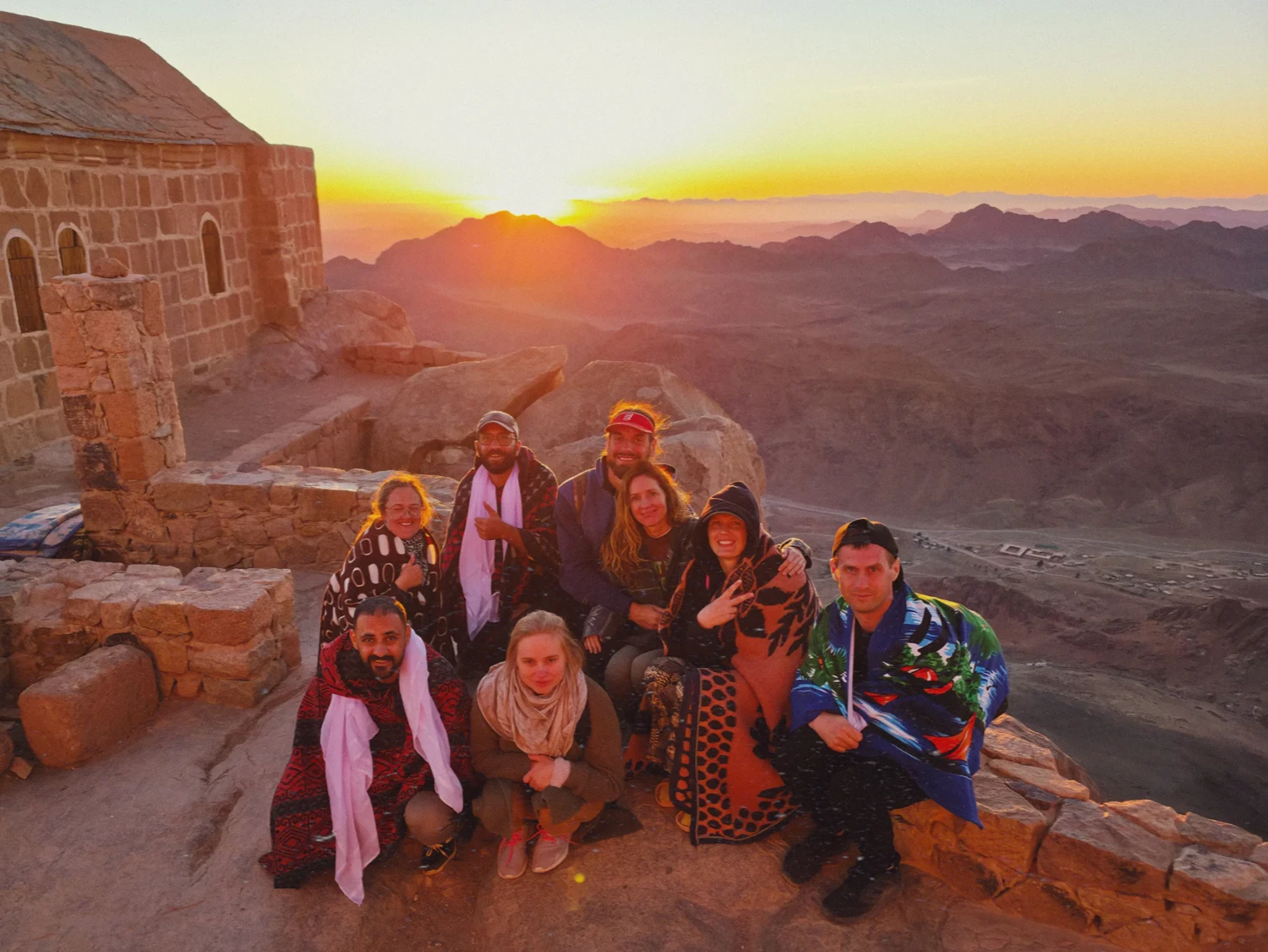 Egipto kelionės grupė su gidais stebi saulėtekį Sinajaus kalnuose